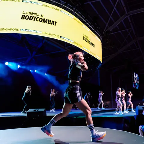 Les Mills BODYCOMBAT instructor performing on stage