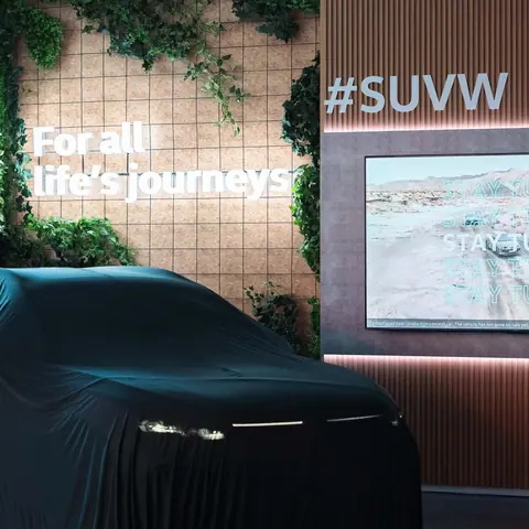 Covered car awaiting its reveal at a Volkswagen launch event