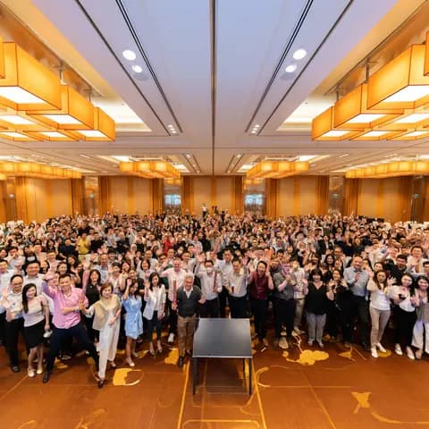 Large corporate audience gathered in a hotel ballroom